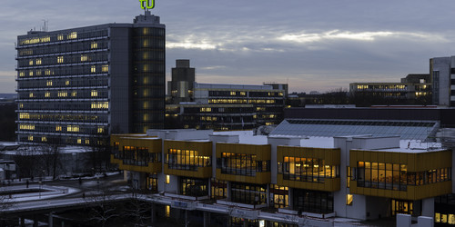Maths Tower and dining hall at dusk in winter.